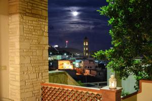 - une vue sur la ville la nuit depuis une fenêtre dans l'établissement Leuca Residence, à Leuca