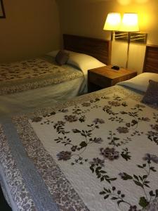 a hotel room with two beds with flowers on them at Buffalo Lodge in Chugwater