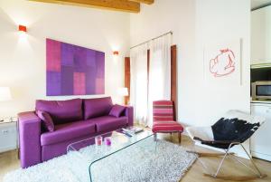 un soggiorno con divano viola e tavolo in vetro di Valencia Luxury - Boutique Redonda a Valencia