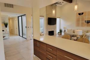 una cucina e un soggiorno con divano e camino di High-End Mid-Century Condo on the golf course a Palm Desert