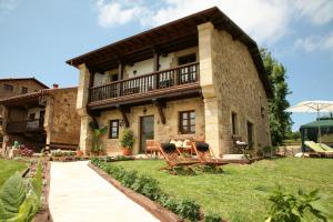 a large stone house with a porch and a patio at Posada Sel de Breno in Udias