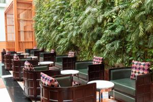クウェートにあるCrowne Plaza Kuwait Al Thuraya City by IHGの緑の壁前の椅子とテーブル