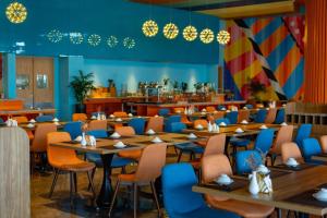 a restaurant with tables and chairs and a cafeteria at FLAMING0 Ibiza Hải Tiến Resort in Thanh Hóa