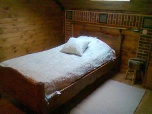 ein Schlafzimmer mit einem Bett in einem Holzzimmer in der Unterkunft Lebrognois in Maison