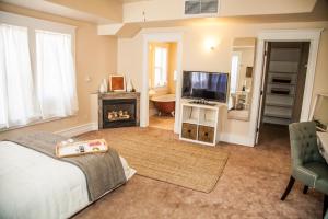 1 dormitorio con cama, TV y chimenea en Grand Circle Lodge, en Kanab