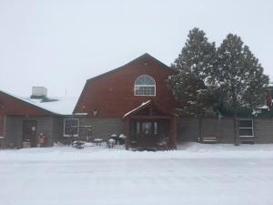 a large red barn with snow in front of it at Buffalo Lodge in Chugwater