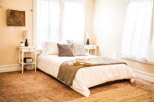 um quarto com uma cama com lençóis brancos e janelas em Grand Circle Lodge em Kanab