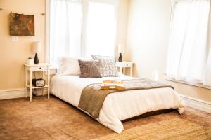 a bedroom with a bed with white sheets and windows at Grand Circle Lodge in Kanab