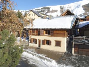 una casa con la neve sul tetto di Chalet spacieux 8 pièces, 15 pers, sauna, cheminée, Les Deux Alpes - FR-1-811-22 a Les Deux Alpes
