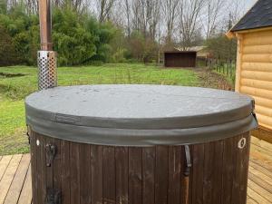 a wooden barrel with a concrete top on a deck at Kota finlandais avec bain nordique privatif et ferme pédagogique - FR-1-410-457 in Cérans-Foulletourte