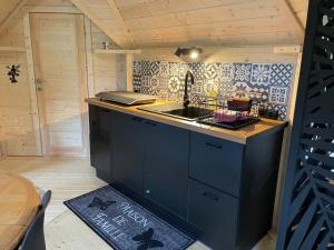 a kitchen with a sink and a counter top at Kota finlandais avec bain nordique privatif et ferme pédagogique - FR-1-410-457 in Cérans-Foulletourte