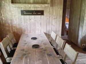 une table en bois avec des chaises et un panneau mural dans l'établissement Cabane Trappeur Lodge avec Jacuzzi et Ferme Pédagogique - FR-1-410-458, à Cérans-Foulletourte 1 autre photo