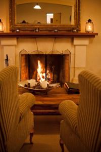 a living room with a fireplace with a table and two chairs at Browns Boutique Hotel in Queenstown