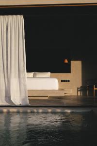 ein Schlafzimmer mit einem Bett und einem Swimmingpool in der Unterkunft SIVANA, Hotel Boutique with ocean or garden views - Adults only in Uluwatu