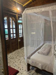 una camera con letto a baldacchino di Fernandes Bar and Restaurant a Canacona