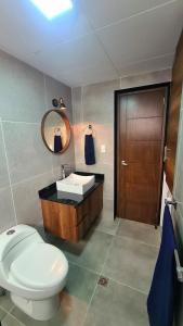 ein Badezimmer mit Toilette, Waschbecken und Spiegel in der Unterkunft Nuevo Estudio de Lujo en el corazón de San Miguel in La Paz