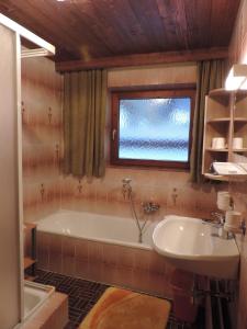 ein Badezimmer mit einer Badewanne und einem Waschbecken in der Unterkunft Ferienwohnung Johann Niedermoser in Fieberbrunn
