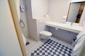 ein Badezimmer mit Toilette, Waschbecken und Spiegel in der Unterkunft Zefyr Hotel in Bodø