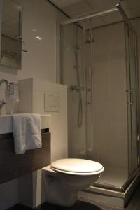 a bathroom with a toilet and a glass shower at Fletcher Hotel Het Veluwse Bos in Beekbergen