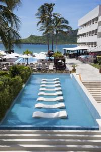 a swimming pool with lounge chairs and a resort at Emporio Mazatlan in Mazatlán