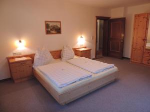 ein Schlafzimmer mit einem großen Bett mit zwei Nachttischen in der Unterkunft Ferienwohnung Johann Niedermoser in Fieberbrunn