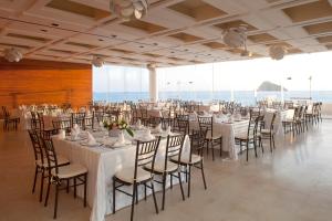 a banquet hall with white tables and chairs at Emporio Mazatlan in Mazatlán