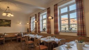 a dining room with tables and chairs and windows at Gasthaus zur Krone in Weingarten