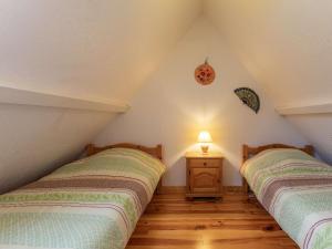 2 Betten im Dachgeschoss mit einer Lampe auf einem Tisch in der Unterkunft Appartement T4 7 pers, parking, proche stations ski - FR-1-402-145 in Luz-Saint-Sauveur + 1 Foto