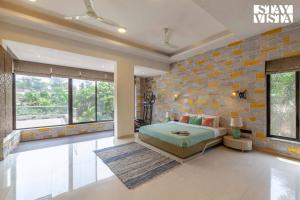 a bedroom with a bed and a brick wall at StayVista's Greystone Estate with Pool, Terrace, and Snooker Table in Lonavala +32 photos