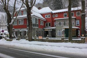 eine Gruppe roter Häuser mit Schnee auf dem Boden in der Unterkunft Hotel Rathaus in Wildemann