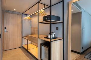 a walk in pantry with a coffee maker on a shelf at Park Inn & Suites by Radisson Thrissur East Fort in Trichūr