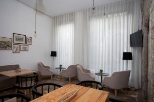 a dining room with tables and chairs and curtains at Belomont52 Guest House in Porto
