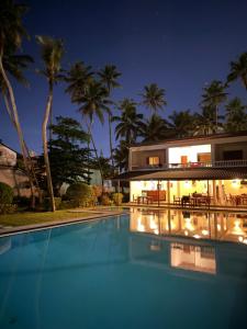 a villa with a swimming pool at night at Crystal Villa Weligama in Weligama