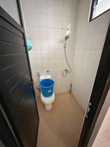 a bathroom with a toilet with a blue bucket at Villa FiFa in Blimbing +7 photos