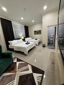 a hotel room with two beds and a couch at SZ Hotel in Melaka