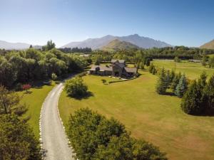 a house in the middle of a field with a gravel road at Three Thirty B & B in Queenstown