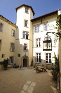 un grand bâtiment avec une table en face dans l'établissement Maison de la Pra, à Valence