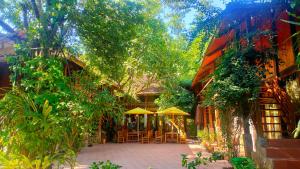 un patio con mesas, sombrillas y árboles en Fairy House Mai Châu, en Mai Chau