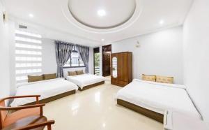 une chambre avec trois lits et un plafond arrondi dans l'établissement Villa Thol DL - by BAY LUXURY, à Đà Lạt