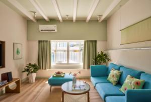 a living room with a blue couch and a table at The Urban Resort by CIRCADIAN in Ho Chi Minh City