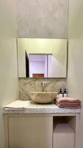 a bathroom with a sink with a large mirror at OKU Guest House in Giri