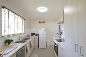 a kitchen with a white refrigerator and a sink at Family Retreat in Central Tenterfield in Tenterfield +8 photos