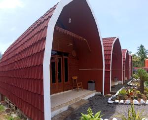 a red house with a red roof at Indah Damai Cottages in Sidomukti