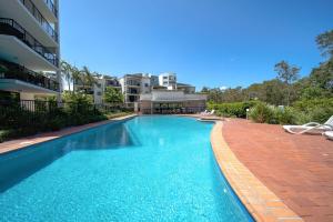 a swimming pool in front of a apartment building at Unit 10 Marcoola Beach Resort in Marcoola