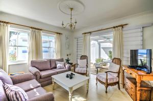 a living room with a couch and a table at Mermaid Rock Cottage in Cape Town