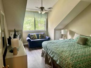 默特尔比奇Exquisite 3 bedroom, 3 bath villa - 19E West Hyde Park - Kingston Plantation villa的一间卧室，有一张床和一张蓝色沙发