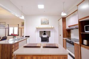 una grande cucina con piano cottura e camino di Heritage Home with BBQ & Outdoor Fire Pit a Tenterfield