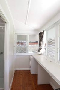 una cucina bianca con un bancone e una finestra di Heritage Home with BBQ & Outdoor Fire Pit a Tenterfield Altre 28 foto