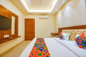 a bedroom with a bed with a television in it at FabHotel K9 Royal in Ludhiana