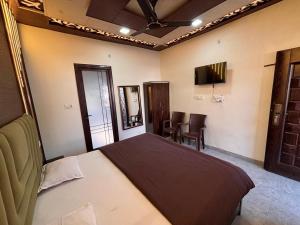 a bedroom with a bed and a television in it at Hotel The Shivraat in Rishīkesh